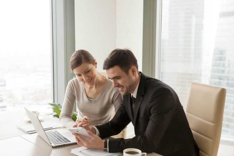 two coworkers in the office talking about phone system features that will help small business thrive