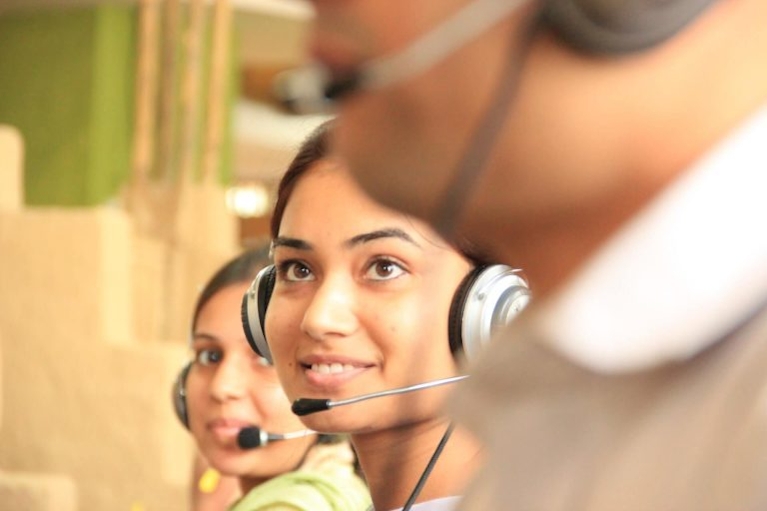 outbound call center agent with black and silver headphones