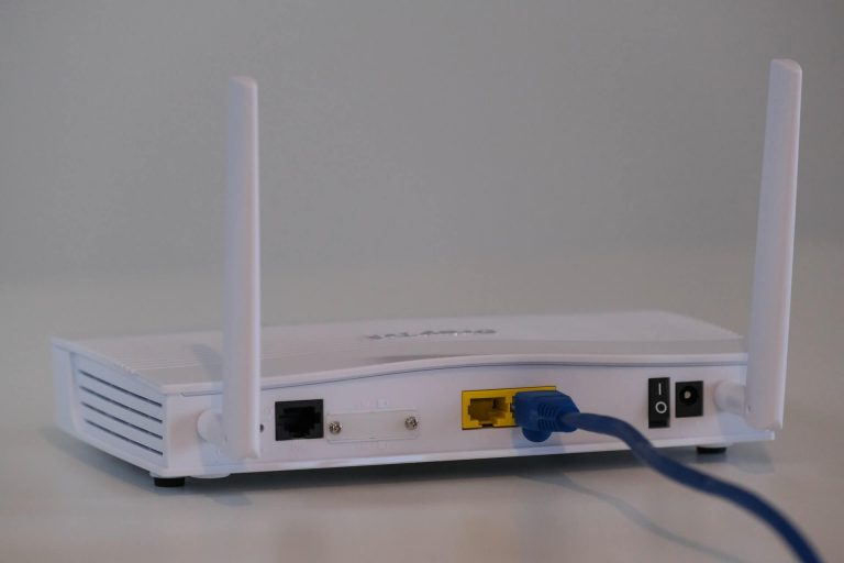 white voip router with blue cable on a white table