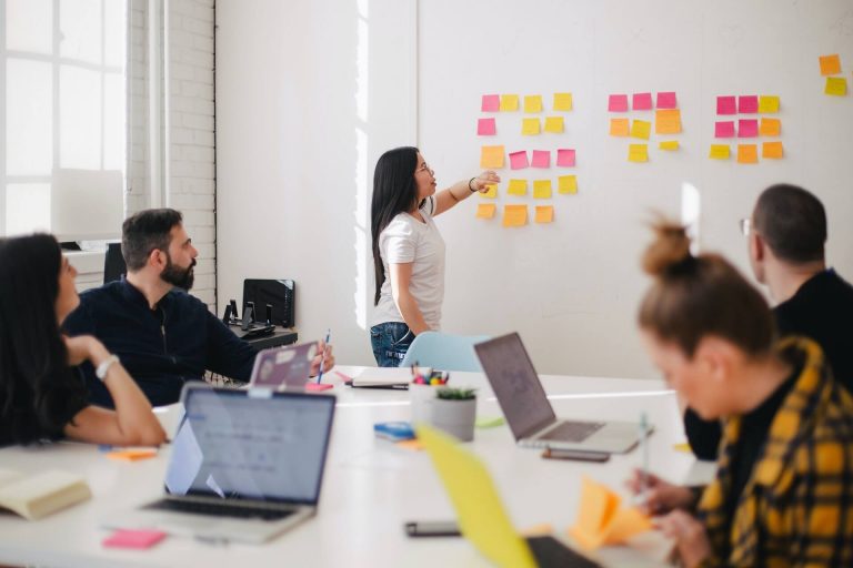 woman in a business meeting talking about the 4 types of communication styles in the workplace